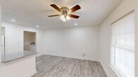 Located on Malabu Drive in Lexington, Kentucky, this efficiently designed 2-bedroom, 1-bathroom single-floor unit offers a thoughtfully updated interior with clean, modern finishes throughout. The open living area features light gray luxury vinyl plank flooring, recessed lighting, and a ceiling fan with a light fixture, creating a bright and airy atmosphere. The kitchen is a standout feature, boasting granite countertops, white cabinetry with black hardware, a classic subway tile backsplash, a peninsula with an undermount sink, and white appliances including an electric range, dishwasher, and refrigerator, complemented by an overhead microwave. Natural light filters in through a window adjacent to the entry door. Both bedrooms are finished with warm carpeting and ceiling fans. The primary bedroom includes a closet, while the second bedroom offers convenient access to the hallway. The full bathroom is finished with wood-look flooring and features a tub-shower combo with a clean white surround, a toilet, and a vanity. A hallway connects the main living spaces, and the unit includes an electrical panel conveniently located in the kitchen area. The overall design emphasizes a clean, neutral palette that makes the space feel fresh and move-in ready.