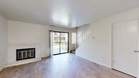Located at 5858 Morgan Place in Stockton, CA, this two-floor unit offers a well-organized layout spread across two levels. The ground floor hosts the main living areas, where light wood-style flooring flows throughout the open kitchen and living room. The living room is bright and inviting, featuring a classic fireplace with a tile surround, a ceiling fan, and a sliding glass door that opens to a private balcony with outdoor views. The adjacent kitchen is efficiently designed with warm wood cabinetry, granite-style countertops, a breakfast bar peninsula, and includes a refrigerator and electric range. A staircase connects the ground floor to the upper level, where both bedrooms are located. The carpeted bedrooms offer a comfortable feel, with large windows that invite natural light and views of the surrounding greenery. The spacious primary bedroom includes a dedicated closet, while the second bedroom also features a sliding-door closet for ample storage. The upper floor also includes an additional closet for extra organization. Clean white walls and neutral finishes throughout the home create a bright, move-in-ready atmosphere suited for comfortable everyday living.
