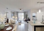 Located at 20941 San Simeon Way in Miami, FL, this single-floor residence offers a thoughtfully designed open-concept layout filled with natural light and modern finishes throughout. The living area is bright and welcoming, featuring large sliding glass doors that open to an outdoor space, a ceiling fan, and large-format tile flooring that flows seamlessly through the common areas. A generously sized kitchen serves as the heart of the home, showcasing dark espresso cabinetry, granite countertops, stainless steel appliances including a refrigerator, range, and built-in microwave, plus a double-basin sink and pendant lighting overhead. A granite-topped breakfast bar provides additional seating and connects the kitchen to the dining and living spaces. The bedrooms offer a calm retreat; the primary bedroom features soft, neutral tones and ample closet space, while the secondary bedroom includes a sliding-door closet and natural light from a window with blinds. Both bathrooms are finished with granite vanities, dark cabinetry, tile flooring, and shower-tub combinations. A dedicated in-unit laundry area houses a full-size washer and dryer with overhead shelving for storage, adding everyday convenience to this well-equipped Miami residence.
