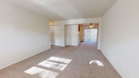 Located at 14A Fox Ridge Dr in Hi Nella, New Jersey, this single-floor unit offers a practical and comfortable layout with a clean, neutral aesthetic throughout. The open living area is finished with wall-to-wall carpeting that extends through the space, allowing natural light to filter in and brighten the interior. A ceiling fan adds a functional touch to the adjoining area, which connects to a sliding glass door dressed with vertical blinds. Baseboard heating is present throughout, ensuring consistent warmth. The layout flows efficiently from the living space to a well-appointed kitchen featuring warm-toned wood cabinetry, granite-style countertops, tile flooring, and a full suite of white appliances including a gas range, dishwasher, and refrigerator. A window above the sink brings in natural light. The bedroom is a comfortable, carpeted room with a window overlooking outdoor greenery and baseboard heating along the perimeter. The bathroom is tidy and functional, appointed with tile flooring, a vanity with wood cabinetry, a white countertop, and a tub-shower combination. Overall, the space presents a straightforward and livable environment with consistent finishes throughout.