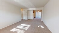 Located at 14A Fox Ridge Dr in Hi Nella, New Jersey, this single-floor unit offers a practical and comfortable layout with a clean, neutral aesthetic throughout. The open living area is finished with wall-to-wall carpeting that extends through the space, allowing natural light to filter in and brighten the interior. A ceiling fan adds a functional touch to the adjoining area, which connects to a sliding glass door dressed with vertical blinds. Baseboard heating is present throughout, ensuring consistent warmth. The layout flows efficiently from the living space to a well-appointed kitchen featuring warm-toned wood cabinetry, granite-style countertops, tile flooring, and a full suite of white appliances including a gas range, dishwasher, and refrigerator. A window above the sink brings in natural light. The bedroom is a comfortable, carpeted room with a window overlooking outdoor greenery and baseboard heating along the perimeter. The bathroom is tidy and functional, appointed with tile flooring, a vanity with wood cabinetry, a white countertop, and a tub-shower combination. Overall, the space presents a straightforward and livable environment with consistent finishes throughout.
