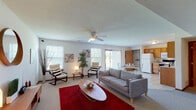 This two-floor residence offers a well-organized and functional layout spread across two levels. The main floor centers around a spacious open-concept living and dining area, bathed in natural light from multiple windows and a sliding glass door that connects the interior to the outdoors. The living room features plush carpeting, a ceiling fan, and generous room for seating and relaxation. A tiled dining area flows seamlessly into the kitchen, which is outfitted with warm oak cabinetry, a full suite of white appliances including a refrigerator, electric range, and built-in microwave, as well as ample counter space and a double sink. A pantry area provides additional storage. The tiled entryway offers a clean transition into the home. A full bathroom on the main level features a wide vanity with generous counter space, a tub-shower combination, and tile flooring. Upstairs, the bedrooms are carpeted and well-proportioned, each with ceiling light fixtures and windows that bring in natural light. One bedroom includes a vaulted ceiling, adding a sense of height and openness. Throughout the home, neutral tones, wood-trimmed doors, and consistent finishes create a cohesive and welcoming atmosphere suited to a variety of lifestyles.