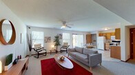 This two-floor residence offers a well-organized and functional layout spread across two levels. The main floor centers around a spacious open-concept living and dining area, bathed in natural light from multiple windows and a sliding glass door that connects the interior to the outdoors. The living room features plush carpeting, a ceiling fan, and generous room for seating and relaxation. A tiled dining area flows seamlessly into the kitchen, which is outfitted with warm oak cabinetry, a full suite of white appliances including a refrigerator, electric range, and built-in microwave, as well as ample counter space and a double sink. A pantry area provides additional storage. The tiled entryway offers a clean transition into the home. A full bathroom on the main level features a wide vanity with generous counter space, a tub-shower combination, and tile flooring. Upstairs, the bedrooms are carpeted and well-proportioned, each with ceiling light fixtures and windows that bring in natural light. One bedroom includes a vaulted ceiling, adding a sense of height and openness. Throughout the home, neutral tones, wood-trimmed doors, and consistent finishes create a cohesive and welcoming atmosphere suited to a variety of lifestyles.
