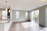 Located at 1000 Ellis Drive in Glen Mills, PA, this well-appointed two-bedroom, two-bathroom residence offers a thoughtfully designed single-floor layout. A clean, light-filled hallway with hard-surface flooring serves as the entry corridor, leading toward the heart of the home. The kitchen is a standout feature, showcasing bold navy-blue cabinetry in one configuration alongside dark espresso cabinetry with granite countertops, stainless steel appliances including a refrigerator, range, and microwave, a tile backsplash, and pendant lighting. A granite-topped breakfast bar connects the kitchen to the open living area, which is bathed in natural light from multiple windows and a sliding glass door that opens to a private balcony overlooking the surrounding community and greenery. The living space features hardwood-style flooring throughout. Both bedrooms offer plush carpeting and ceiling fans, with windows that bring in natural light. The primary bedroom provides a comfortable, well-sized retreat. The bathrooms are finished with large-format tile flooring, granite-topped vanities, and clean, neutral finishes. Additional features include in-unit laundry and generous closet storage throughout.