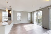 Located at 1000 Ellis Drive in Glen Mills, PA, this well-appointed two-bedroom, two-bathroom residence offers a thoughtfully designed single-floor layout. A clean, light-filled hallway with hard-surface flooring serves as the entry corridor, leading toward the heart of the home. The kitchen is a standout feature, showcasing bold navy-blue cabinetry in one configuration alongside dark espresso cabinetry with granite countertops, stainless steel appliances including a refrigerator, range, and microwave, a tile backsplash, and pendant lighting. A granite-topped breakfast bar connects the kitchen to the open living area, which is bathed in natural light from multiple windows and a sliding glass door that opens to a private balcony overlooking the surrounding community and greenery. The living space features hardwood-style flooring throughout. Both bedrooms offer plush carpeting and ceiling fans, with windows that bring in natural light. The primary bedroom provides a comfortable, well-sized retreat. The bathrooms are finished with large-format tile flooring, granite-topped vanities, and clean, neutral finishes. Additional features include in-unit laundry and generous closet storage throughout.