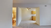 Located at 300 Hidenwood Place in Newport News, Virginia, this single-floor residence offers a practical and comfortable layout designed for easy living. The main living area is finished with wall-to-wall carpeting, creating a warm and inviting atmosphere, and is equipped with a ceiling fan that promotes air circulation throughout the space. An open-concept design connects the living area directly to the kitchen, which features warm-toned wood cabinetry, ample upper and lower storage, and a countertop workspace suitable for everyday meal preparation. The seamless flow between these two areas makes the space feel open and functional. A full bathroom is accessible from the living area and includes a toilet, sink with vanity, and a tiled shower/tub combination, providing all essential amenities. The neutral color palette used throughout — from the light walls to the carpeted floors — lends a clean, versatile backdrop well-suited to a variety of décor styles. The overall layout is efficient and cohesive, making this single-story residence a straightforward and comfortable option in the Hidenwood neighborhood of Newport News.