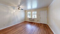 Located at 3401 Garden Oaks Dr in New Orleans, LA, this single-floor, 1-bedroom, 2-bathroom residence offers a practical and comfortable layout designed for efficient living. The living room serves as the heart of the home, featuring warm hardwood-style flooring that runs throughout the unit, crown molding, and a ceiling fan with light fixture. Natural light filters in through windows fitted with blinds, creating a bright and inviting atmosphere. The space flows openly into the adjoining areas, giving the home an airy feel despite its cozy footprint.

The kitchen is accessible via a charming pass-through window with a built-in ledge, ideal for casual dining or serving. It is equipped with light wood cabinetry, granite-look countertops, a white electric range, and a refrigerator, providing all the essentials in a compact, well-organized space.

The bedroom offers a comfortable retreat with its own ceiling fan, hardwood-style flooring, crown molding, a window with natural light, and a wall-unit HVAC system for year-round comfort. A closet provides dedicated storage. The two bathrooms are clean and functional, one featuring a full tub-shower combination with tiled surround, and a vanity with a mirrored medicine cabinet. Textured walls add a subtle design detail throughout the bathrooms.