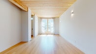 This four-floor property showcases a cohesive modern design anchored by a signature element found throughout: warm, natural wood plank ceilings that lend texture and organic character to every room. Light hardwood flooring flows through the main living areas, complementing the crisp white walls and creating a bright, airy atmosphere.

The kitchen is a standout space, featuring white shaker cabinetry, quartz countertops, a central island, subway tile backsplash, and high-end stainless appliances including a double-oven range and French door refrigerator. Pendant lighting and large windows flood the room with natural light and outdoor views.

The living area is open and generously proportioned, with sheer-curtained windows drawing in sunlight. Bedrooms are carpeted for comfort, with wood ceilings continuing the home's natural aesthetic, and connect to well-designed bathrooms finished with hexagonal tile flooring, quartz vanities, brass fixtures, glass-enclosed showers, and stylish globe sconce lighting.

A staircase with natural wood treads connects the floors, and an attached garage with a wood-paneled ceiling and transom windows completes the property.
