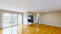 Located at 161 Capricorn Dr in Hillsborough, NJ, this single-floor residence offers 2 bedrooms and 2 bathrooms within a well-organized layout. Gleaming hardwood floors run throughout the living areas and bedrooms, lending warmth and continuity to the space. The open living and dining area is a standout feature, bathed in natural light from a large sliding glass door fitted with vertical blinds that provide both privacy and outdoor views. The kitchen is thoughtfully appointed with dark espresso cabinetry, a full suite of black appliances including a refrigerator, electric range, and microwave, and light tile flooring, all illuminated by a skylight above. The spacious primary bedroom offers generous room for furnishings, baseboard heating, and natural light from large windows with views of surrounding greenery. The second bedroom is comparably bright with its own window and hardwood floors. A dedicated closet provides additional storage. The two bathrooms are cleanly finished, one featuring a framed mirror, dark vanity cabinetry, and a white countertop. Baseboard heating is present throughout the unit. The neutral color palette and clean finishes give the space a bright, move-in-ready ambiance.