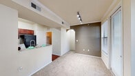 This single-floor residence offers a thoughtfully designed layout that balances comfort and functionality throughout. The living area is finished with plush carpeting and features crown molding, a ceiling fan, and an elegant arched doorway that connects the spaces with architectural charm. Natural light flows generously through multiple windows, providing pleasant views of surrounding greenery.

The kitchen is a standout feature, showcasing rich cherry-toned cabinetry extending to the ceiling, a full suite of black appliances including a range, microwave, and refrigerator, a double-basin sink, and durable hardwood-style flooring. A breakfast bar connects the kitchen to the open living and dining area, which is accented by track lighting and a warm accent wall.

The bedrooms are carpeted and well-lit, each equipped with ceiling fans and windows that bring in ample natural light. The primary suite includes access to a spacious walk-in closet with wire shelving systems for organized storage.

The bathrooms are finished with hardwood-style flooring and rich wood-toned vanity cabinetry. One bathroom features a wide, elongated layout with a tub-shower combination, while another offers a similarly appointed design. A utility area with an electrical panel provides additional practicality. Overall, the space presents a clean, cohesive aesthetic with warm finishes throughout.
