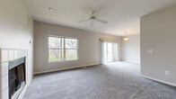 This single-story, 2-bedroom, 2-bathroom home offers a thoughtfully organized layout across one level. The expansive living room is a standout feature, highlighted by vaulted ceilings, a ceiling fan, soft carpet flooring, and abundant natural light streaming through large windows and a sliding glass door that opens to an outdoor patio. A decorative tiled fireplace anchors one end of the living area, adding warmth and character to the space. A pendant light fixture marks the adjoining dining area, which flows seamlessly from the main living space. The kitchen features warm oak cabinetry in a U-shaped configuration, light tile flooring, a full suite of appliances including a dishwasher, electric range, and refrigerator, complemented by a ceiling-mounted light fixture for bright task lighting. Both bedrooms are carpeted and filled with natural light from windows overlooking the surrounding neighborhood, with ceiling fans providing comfort. The primary bedroom is generously sized and includes access to a closet. The two bathrooms are clean and functional; one features tile flooring, an oak vanity with a single sink, and a tub-shower combination with a glass sliding door. The neutral color palette and consistent finishes throughout give the home a cohesive, move-in-ready feel.