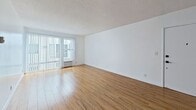 This 630-square-foot, one-bedroom, one-bathroom apartment is located at 310 S Almont Dr, Unit 311, in the desirable Beverly Grove neighborhood of Los Angeles, CA. The single-floor layout flows efficiently through a hallway connecting all rooms. The open living area features warm hardwood flooring and a textured ceiling, with large sliding glass doors that flood the space with natural light and provide access to a balcony. The galley-style kitchen is well-appointed with white cabinetry, granite countertops, stainless steel appliances including a refrigerator, wall oven, microwave, and dishwasher, and a peninsula that opens to the living area. The 160-square-foot primary bedroom offers hardwood floors, a wide window for natural light, and a full-width mirrored sliding closet. The bathroom is outfitted with a granite-topped vanity featuring a vessel sink and white cabinetry, a large mirror, and a combination shower and soaking tub with chrome fixtures and tile surround. Clean white walls throughout the unit contribute to a bright, neutral aesthetic ideal for personalization.