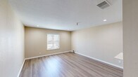 Located at 9524 E 71st St in Tulsa, Oklahoma, this efficient single-story, one-bedroom, one-bathroom unit offers a well-organized layout with a comfortable entrance, a living room, a bedroom, and a bathroom. Throughout the space, light wood-style flooring creates a warm, cohesive look that ties each room together seamlessly.

The living room is a bright, open area featuring recessed lighting, a textured ceiling, and neutral beige walls that lend a clean and welcoming atmosphere. A pass-through shelf connects the living space to an adjacent area, adding a practical architectural touch. Natural light filters in through windows fitted with white blinds.

The bedroom is a generously sized private retreat, highlighted by a ceiling fan with a light fixture, a closet, and continued wood-style flooring. A window with blinds allows for natural light and ventilation, while the neutral tones maintain a calm, restful ambiance.

The bathroom is well-appointed with a white vanity featuring a stone-topped countertop, a mirror, and a walk-in shower with white tile surround and chrome fixtures. Wood-style flooring continues into this space, reinforcing the consistent design aesthetic found throughout the unit.

Overall, this space presents a tidy, functional layout with a cohesive neutral palette, durable finishes, and practical features suited for comfortable everyday living.