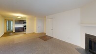 Located at 1304 Stoneypointe Dr in Rock Hill, South Carolina, this single-floor residence offers a well-organized layout with a variety of functional living spaces. The living room serves as a central gathering area, highlighted by a classic wood-burning fireplace with a clean white mantel and a sliding glass door fitted with vertical blinds that allows natural light to fill the room. Neutral-toned carpet extends throughout the living and bedroom areas, creating a cohesive and comfortable feel.

The kitchen is a standout feature, outfitted with dark espresso cabinetry, white countertops, a subway tile backsplash, and a full suite of stainless steel appliances including a range, over-the-range microwave, and refrigerator. Light wood-style flooring runs through the kitchen, complementing the contemporary cabinetry hardware.

The bedroom spaces are generously proportioned with neutral carpet, cream-toned walls, and textured ceilings, providing a clean and versatile canvas. A bathroom is present with wood-style flooring, and includes a toilet and towel bar, with additional bathroom fixtures visible in the dollhouse overview.

From the entry area, the layout flows naturally toward the kitchen, with additional interior doors providing access to closets and secondary rooms. The overall design is practical and move-in ready, suited for comfortable everyday living.