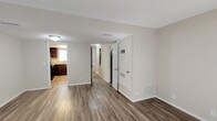 This two-story, 3-bedroom, 1.5-bathroom home offers a practical and comfortable layout designed for everyday living. Throughout the space, durable wood-look flooring in a warm tone flows consistently, complemented by neutral walls and textured ceilings that lend a clean, cohesive aesthetic.

The living area is bright and inviting, highlighted by a sliding glass patio door fitted with vertical blinds that allows generous natural light and views of the surrounding greenery. The space opens conveniently toward the kitchen, which features rich dark wood cabinetry, light granite-style countertops, a double stainless steel sink, and a gas range — providing ample storage and functionality for cooking and entertaining.

Each of the three bedrooms is well-proportioned and naturally lit through sizable windows with blinds. The rooms offer neutral walls and consistent flooring, making them easily adaptable to a variety of uses.

The full bathroom includes a tub-shower combination, a dark wood vanity with a white countertop, and a well-lit mirror, while a half bath provides added convenience. The hallway area features multiple closets, offering practical storage solutions throughout the home. The two-story layout, visible in the dollhouse view with a staircase featuring a decorative railing, adds a sense of dimension and separation between living and sleeping areas.