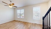 Located at 1300 Stanley Avenue Ext in Chambersburg, PA, this well-appointed 3-story home offers four bedrooms, three bathrooms, and a thoughtfully organized layout across three distinct floors. The ground level houses a garage with tile flooring and ample wall space, providing convenient parking and storage. The main living floor features an open combined dining room and kitchen outfitted with gray shaker-style cabinetry, granite countertops, stainless steel appliances, and light wood-look flooring. A dedicated pantry sits just off the kitchen for additional storage. The living room is bright and welcoming, featuring ceiling fans and large windows with blinds that allow generous natural light and views of the surrounding neighborhood. A staircase with dark wood banisters and carpet treads connects the floors, complemented by clean white walls and light hardwood-style flooring throughout the hallways. The upper floors host the four bedrooms, including a spacious primary suite. Bedrooms feature plush carpet flooring, ceiling fans, and windows offering outdoor views. Three closets provide practical storage throughout. The three bathrooms are finished with granite-top vanities, shaker-style cabinetry, and tub-shower combinations. A dedicated laundry room on the upper level includes a full-size washer and dryer with built-in shelving above.