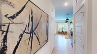 Located at 5111 Abercorn St in Savannah, Georgia, this well-designed one-bedroom, one-bathroom residence offers a thoughtful layout across a single floor. Light hardwood flooring runs throughout, providing a cohesive and clean aesthetic that ties each space together.

The entry hallway sets the tone with gallery-worthy wall space, leading into the open-plan kitchen and living area. The kitchen is a functional standout, featuring dark granite countertops, white lower cabinetry paired with rich wood-toned upper cabinets, a white tile backsplash, and a full suite of stainless steel appliances including a side-by-side refrigerator, range, microwave, and dishwasher. Open shelving adds additional storage and display space, while a trio of pendant lights provide focused task lighting overhead. A dedicated pantry offers extra storage convenience.

The living area is bright and welcoming, with large windows and a glass door that invite abundant natural light and views of greenery outside. The bedroom is a calm retreat with elevated ceilings, a dedicated closet, and a clerestory window that allows soft, indirect light to filter in. A full bathroom and a utility room complete the layout. Two closets provide practical storage throughout the residence.