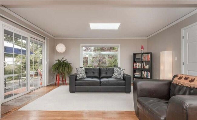 Living room with large viewing window and a double door slider to the back yard - 1319 Gemini St SE