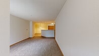 Located at 12851 W Wyndridge Ct in New Berlin, Wisconsin, this one-bedroom, one-bathroom residence offers a well-organized single-floor layout designed for comfortable everyday living. The open-concept living room flows seamlessly into the kitchen, creating a connected, airy feel. The living area features neutral-toned carpet, clean white walls, and warm wood baseboards, lending a cohesive and inviting atmosphere throughout. A decorative pendant chandelier provides a focal point between the two spaces.

The kitchen is equipped with warm oak cabinetry offering generous upper and lower storage, white appliances including a refrigerator, electric range, and built-in microwave, and light-toned countertops. A curved breakfast bar separates the kitchen from the living area, adding both functionality and visual interest. Tile flooring runs throughout the kitchen for easy maintenance.

The bedroom is a well-proportioned, carpeted room featuring a large window that brings in natural light and a six-panel wood door. The neutral palette creates a calm, restful environment.

The bathroom includes a full soaking tub and shower combination with clean white surrounds and tile flooring. A hallway connects the main living spaces to the private areas of the home, completing this efficiently designed and move-in-ready residence.