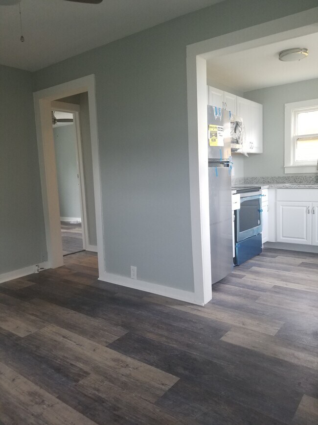 Living room with archways to kitchen and hall. - 5013 Avenue M