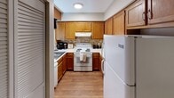 Located at 1260 5th St NE in Hickory, North Carolina, this single-story home offers a well-organized layout designed for comfortable everyday living. The floor plan reveals multiple bedrooms, a kitchen, dining area, and living space, all contained within a cohesive and functional arrangement.

The bedrooms are carpeted and feature ceiling fans with integrated lighting, providing both comfort and airflow year-round. Each room is fitted with windows dressed in horizontal blinds and curtain panels, allowing for adjustable natural light. Closet space is provided through louvered bifold doors, offering practical storage. The warm, neutral wall tones throughout create a calm and welcoming atmosphere.

The kitchen is equipped with honey-toned wood cabinetry, a tile backsplash, and light hardwood-style flooring. It includes a full suite of appliances — electric range, refrigerator, and sink — arranged in an efficient layout that maximizes use of the available space. Overhead lighting keeps the kitchen well-lit and functional.

The overall interior maintains a consistent aesthetic with textured ceilings, neutral paint tones, and wall-to-wall carpeting in the bedroom areas. The home's single-floor design ensures easy accessibility throughout, making it a straightforward and practical residence in the Hickory community.