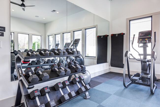 Club-quality fitness studio with free weights and elliptical. This image is a representation of the fitness studio at Amavi Brier Creek and is tentatively scheduled to open Summer 2025. - Amavi Brier Creek