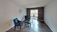This single-floor, 2-bedroom, 2-bathroom residence is thoughtfully laid out to maximize functionality across its well-defined living spaces. The living room serves as the central gathering area, featuring wood-style flooring, a textured ceiling, and a large sliding glass door that fills the space with natural light while providing access to an outdoor balcony area. A ceiling fan adds to the comfort of the adjacent dining and kitchen area.

The galley-style kitchen is equipped with rich, dark wood cabinetry offering generous upper and lower storage, light-toned countertops, a double stainless steel sink, a white electric range, and a dishwasher. Wood-style flooring continues throughout this area, enhancing the cohesive feel of the main living spaces.

Both bedrooms feature plush carpeting and windows that allow natural light to filter in. The primary bedroom includes a walk-in closet, providing notable storage capacity. The second bedroom is equally comfortable, offering a quiet, neutral environment.

The two full bathrooms are each appointed with wood-style flooring, a vanity with cabinetry, a toilet, and a full tub-shower combination, providing practical functionality. Overall, the residence presents a clean, neutral palette throughout.