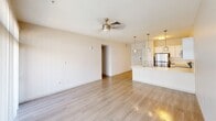 Located at 295 E Roosevelt Street in the heart of Phoenix, AZ, this one-bedroom, one-bathroom unit offers a well-designed open-concept layout across a single floor. The combined kitchen and living area serves as the centerpiece of the home, featuring light hardwood-style flooring that extends throughout and large floor-to-ceiling windows that flood the space with natural light and provide views of the outdoors. A ceiling fan keeps the living area comfortable year-round.

The kitchen is outfitted with sleek white cabinetry, a peninsula island with a built-in stainless steel sink, and stainless steel appliances including an electric range, built-in microwave, and dishwasher. Three pendant lights with brushed gold accents hang above the island, adding a modern, stylish touch.

The bedroom is a generously sized, carpet-floored retreat equipped with its own ceiling fan and a window with blinds that invites natural light. It connects directly to a walk-in closet featuring dual hanging rods and built-in shelving, providing ample storage.

The bathroom is clean and contemporary, showcasing white subway tile surrounding a full soaking tub and shower combo, a white vanity with an undermount sink, and a large mirror with overhead lighting. A hallway connects all areas of the unit seamlessly, completing this thoughtfully laid-out home.