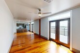 Located in the heart of New Orleans at 427 Josephine St, this well-appointed two-bedroom, two-bathroom residence offers a thoughtfully designed single-level floor plan with a seamless blend of classic character and modern finishes. Rich, warm-toned hardwood floors flow throughout the living areas and bedrooms, creating a cohesive and inviting atmosphere complemented by crisp white walls and ceiling fans in each room.

The open kitchen is a functional centerpiece, featuring dark espresso cabinetry with ample storage, granite countertops, stainless steel appliances including a range, microwave, and refrigerator, and a double-basin sink set into a peninsula that connects to the living area. The kitchen opens toward the front entry, which is framed by natural wood accents and glass-paned doors that draw in natural light.

Both bathrooms are finished with classic black-and-white mosaic tile floors, granite vanity countertops, and full soaking tub-shower combinations, offering clean and timeless aesthetics. The spacious primary bedroom includes access to a dedicated closet and an en-suite bathroom. The second bedroom is well-sized and equally bright.

A standout feature of this residence is the private outdoor deck, which offers sweeping, unobstructed views of the Mississippi River — a rare and memorable amenity that brings the essence of New Orleans directly to your doorstep.