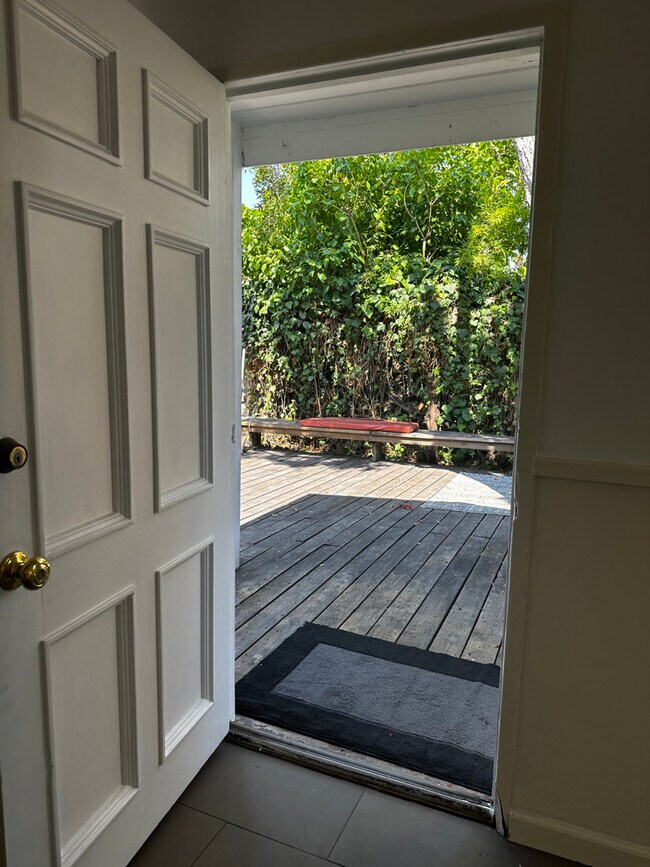 Enter the beach bungalow from the front yard with a large wood deck & built in benches. - 924 Nowita Pl