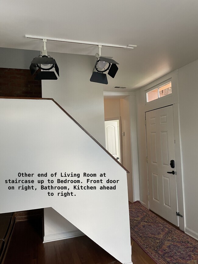 El otro extremo de la sala tiene escaleras que llevan al dormitorio del tercer piso. La puerta de entrada está a la derecha. - 810 E Washington St