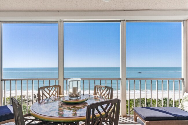 dining, sofa with ottoman, two lounge chairs - 253 Barefoot Beach Blvd