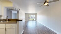 Located at 4500 Woodman Ave in Sherman Oaks, Los Angeles, this one-bedroom, one-bathroom unit offers a thoughtfully organized single-floor layout. The combined living and dining area is bright and open, featuring smooth hardwood-style flooring, a ceiling fan, and a sliding glass door that leads to a private balcony with outdoor views — filling the space with natural light. The kitchen is positioned adjacent to the living area with a peninsula counter that doubles as a breakfast bar, complemented by white cabinetry, dark countertops, and stainless steel appliances including a refrigerator, range, and microwave. The bedroom is a comfortable, well-proportioned room finished with plush carpeting and a window that brings in natural light. Two closets provide generous storage throughout the unit. The bathroom features a wide vanity with dark countertops, white cabinetry, a large mirror, and a shower-tub combination with a sliding glass door, finished with warm wood-tone flooring. Clean, neutral tones throughout the unit create a cohesive and move-in-ready atmosphere well suited to everyday Los Angeles living.