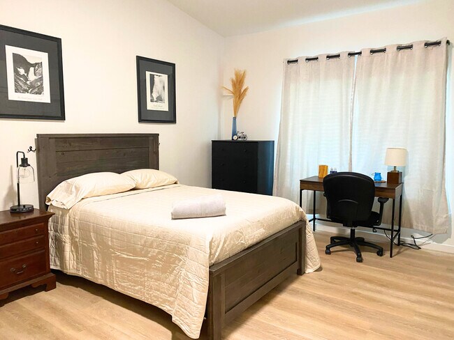 Habitación 5: Habitación espaciosa - Equipada con cama, tocador, mesita de noche y lámpara, caja fuerte personal. - 8941 E 24th Ln