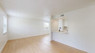 Located at 1799 CR-19A in Eustis, Florida, this single-story, one-bedroom, one-bathroom home offers a clean, modern aesthetic throughout its efficiently designed floor plan. Light wood-tone flooring runs consistently across the entire space, creating a cohesive and airy feel. The open-concept living room is generously sized, featuring multiple windows fitted with blinds that allow abundant natural light to fill the room, along with a textured ceiling and a glass-panel door that opens to the outdoors. The kitchen is configured in a galley layout and is accessible both from the living area via a pass-through counter opening and through a dedicated corridor. It features white cabinetry, stainless steel appliances including a refrigerator, range, microwave, and dishwasher, and a practical overhead light. The bedroom offers a comfortable footprint, a ceiling fan with light, a window for natural light, and direct access to two closets, providing ample storage. The bathroom is well-appointed with a combination tub and shower enclosed in white tile, classic chrome fixtures, and wood-tone flooring. A dedicated utility area houses the water heater and includes wire shelving. The home presents a crisp, move-in-ready appearance throughout.