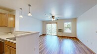 Located at 536 W Washington Ave in Madison, WI, this single-floor, one-bedroom, one-bathroom unit offers a functional and comfortable layout. Warm hardwood-style flooring flows throughout the main living areas and bedroom, complemented by clean white walls and classic wood trim that create a bright, cohesive aesthetic.

The combined kitchen and living area serves as the heart of the space. The kitchen features warm oak cabinetry, light countertops, a full suite of appliances including a stainless steel refrigerator, electric range, built-in microwave, and dishwasher, as well as a peninsula with a breakfast bar that opens to the living area. Pendant lighting accents the kitchen, adding warmth to the space. The living room benefits from a large sliding glass door with vertical blinds, allowing ample natural light and outdoor views, and is equipped with a ceiling fan for added comfort.

The bedroom offers generous proportions, with hardwood-style flooring, a ceiling fan with light fixture, a wall-unit air conditioner, and windows that bring in natural light. A closet provides convenient storage.

The bathroom is well-appointed with warm oak cabinetry, a wide vanity with a light countertop, a full tub-shower combination, and neutral carpeted flooring, maintaining the space's consistent, welcoming character throughout.