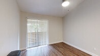 This thoughtfully designed 1-bedroom, 1-bathroom unit offers a functional and efficient single-floor layout across five distinct spaces: an entrance, bedroom, kitchen, bathroom, and closet. Wood-look flooring runs throughout, lending warmth and visual continuity to the entire unit.

The kitchen is a standout feature, outfitted with stainless steel appliances including a refrigerator, dishwasher, range, and built-in microwave. Crisp white shaker-style cabinetry, granite-look countertops, and a classic white subway tile backsplash complete the modern aesthetic.

The bedroom is a comfortable and well-lit retreat, featuring a large window with horizontal blinds that frame views of lush outdoor greenery. A ceiling fan with a light fixture adds practicality. The room connects directly to a dedicated closet, providing convenient storage. Sliding glass doors in the living area, fitted with vertical blinds, allow natural light to fill the space.

The bathroom is finished with refined details, including a vessel sink atop a granite countertop, white shaker-style vanity with drawer storage, a framed mirror with overhead lighting, and a tub-shower combination. Neutral wall tones throughout the unit create a clean, cohesive atmosphere that feels open and inviting.