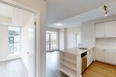 Located at 2550 Eglinton Ave W in Mississauga, this well-appointed 2-bedroom, 2-bathroom unit offers a clean, contemporary design throughout. The open-concept layout connects the kitchen and living area seamlessly, with large floor-to-ceiling windows and a sliding glass door leading to a private balcony that frames expansive views of the Mississauga skyline and surrounding cityscape. The kitchen is equipped with stainless steel appliances including a fridge, stove, and microwave, complemented by crisp white cabinetry, stone countertops, a kitchen island with an integrated sink, and track lighting overhead. Hardwood-style flooring runs throughout the unit, adding warmth and continuity. The primary bedroom features mirrored sliding closet doors and generous windows with wide city views. The second bedroom benefits from a tall window that fills the room with natural light and overlooks the surrounding landscape. Both bathrooms are finished in a modern, neutral palette — one featuring a glass-enclosed shower with white subway tile, and the other a soaker tub with matching tile surround. A bright hallway connects the rooms, completing this efficient and stylish urban residence.