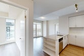 Located at 2550 Eglinton Ave W in Mississauga, this well-appointed 2-bedroom, 2-bathroom unit offers a clean, contemporary design throughout. The open-concept layout connects the kitchen and living area seamlessly, with large floor-to-ceiling windows and a sliding glass door leading to a private balcony that frames expansive views of the Mississauga skyline and surrounding cityscape. The kitchen is equipped with stainless steel appliances including a fridge, stove, and microwave, complemented by crisp white cabinetry, stone countertops, a kitchen island with an integrated sink, and track lighting overhead. Hardwood-style flooring runs throughout the unit, adding warmth and continuity. The primary bedroom features mirrored sliding closet doors and generous windows with wide city views. The second bedroom benefits from a tall window that fills the room with natural light and overlooks the surrounding landscape. Both bathrooms are finished in a modern, neutral palette — one featuring a glass-enclosed shower with white subway tile, and the other a soaker tub with matching tile surround. A bright hallway connects the rooms, completing this efficient and stylish urban residence.
