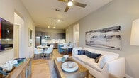 Located in Orlando, FL, this thoughtfully designed 2-bedroom, 2-bathroom residence offers a comfortable and modern living experience across a single floor. The open-concept layout seamlessly connects the living room, dining area, and kitchen, creating a bright and cohesive common space. Light wood-look flooring flows throughout, complemented by neutral gray walls and track lighting that enhance the airy atmosphere. A ceiling fan adds both function and style to the living area, which features large windows and a glass door that invite natural light and provide outdoor views.

The kitchen is a standout, boasting sleek gray shaker cabinetry extending to the ceiling, stainless steel appliances including a refrigerator, range, microwave, and dishwasher, white subway tile backsplash, and light quartz countertops. A kitchen island with bar seating provides additional prep and dining space.

The primary bedroom offers a tranquil retreat with windows overlooking greenery and ample room for a full bedroom suite. Both closets feature wire shelving systems for organized storage. The bathrooms are finished with gray vanities, white countertops, and subway-tiled tub-shower combinations. A connecting hallway ties the private quarters together, completing this well-planned and stylish home.
