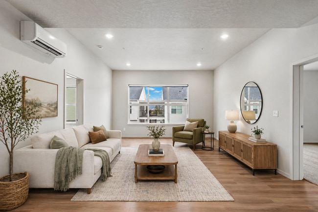 Bright and inviting living room featuring abundant natural light through large windows. - Lofts at Garden District