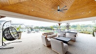 Located at 1 Haddon Blvd in Mount Laurel, New Jersey, this outdoor amenity space is a thoughtfully designed community retreat that offers a range of recreational features set against a backdrop of lush, well-maintained green space. At the heart of the area is a generously sized swimming pool with crystal-clear water, surrounded by a spacious deck lined with lounge chairs and shaded umbrella seating, perfect for relaxing on sunny days. The pool is equipped with an accessible pool lift, ensuring inclusive enjoyment for all residents. Adjacent to the pool, a built-in outdoor grilling station features a stainless steel grill set into a stone surround with a white countertop, providing an ideal space for outdoor cooking and entertaining. A gently curving concrete walking path winds through the manicured grounds, bordered by neatly trimmed hedges, mature trees, and open green lawns that invite leisurely strolls. The pool area is enclosed by a black iron fence with dedicated entry points, enhancing both safety and aesthetics. A covered pavilion structure is visible near the pool deck, offering shaded seating and gathering space. The surrounding landscape includes views of the broader residential community, with multi-story buildings framing the horizon. The entire outdoor space exudes a clean, well-appointed, and welcoming atmosphere ideal for community living.