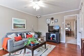 Located at 700 W Magnolia Ave in Auburn, Alabama, this single-floor unit offers a thoughtfully designed layout with consistent finishes throughout. Crown molding and warm hardwood-style flooring carry through the main living areas, giving the space a cohesive and polished feel.

The living room is a welcoming retreat, featuring a ceiling fan, natural light from a window with blinds, and ample space for comfortable seating and entertainment. It flows naturally toward the entryway, which includes a coat rack area and decorative mirror — a practical and stylish welcome point.

The kitchen is well-equipped with white cabinetry, granite-style countertops, and full appliances including a dishwasher, range, and microwave. A breakfast bar peninsula provides casual seating and serves as a natural divider between the kitchen and dining area, making it ideal for everyday meals or entertaining.

The bedroom is carpeted and comfortably proportioned, with crown molding, a ceiling fan, a window for natural light, and room for both a bed and a dedicated workspace. The full bathroom features a granite-topped vanity and a tiled tub/shower combination. Completing the unit is a dedicated laundry room with side-by-side washer and dryer and overhead shelving for additional storage.
