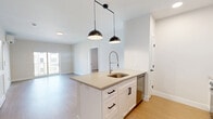Located at 1995 Main St in Stratford, CT, this well-appointed 2-bedroom, 2-bathroom residence offers a thoughtfully designed open-concept layout with modern finishes throughout. Light-toned hardwood-style flooring flows seamlessly across every room, complemented by crisp white walls that create a clean, bright ambiance.

The combined kitchen and living area serves as the heart of the home. The kitchen is equipped with white shaker cabinetry, stainless steel appliances, a quartz countertop island with an undermount sink and industrial-style faucet, and stylish pendant lighting overhead. The living area opens directly onto a private balcony through sliding glass doors, offering views of the surrounding courtyard and building exterior.

The primary bedroom is a generously sized retreat featuring a wall-mounted ductless mini-split unit for personalized climate control and a window that fills the room with natural light. Both bedrooms benefit from dedicated closets outfitted with wire shelving systems for organized storage.

The bathrooms are finished with light hardwood-style flooring, white vanities with ample drawer storage, wide mirrors, and contemporary black hardware. Two walk-in closets provide additional storage convenience. The unit's modern construction, consistent finishes, and functional layout make it a comfortable and stylish living space.