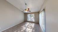 Located at 5320 Thunder Creek Rd in Austin, TX, this single-story, 2-bedroom, 1-bathroom home offers a functional and comfortable layout. The living area features plush carpet flooring, a ceiling fan, and a sliding glass door flanked by vertical blinds that invite natural light and provide outdoor access. The spacious primary bedroom boasts vaulted ceilings, a ceiling fan with light fixture, wide windows with tree-lined views, and a sliding mirror closet door for ample storage. The second bedroom is comparably sized, also carpeted, and benefits from a window that brings in natural light, connecting seamlessly to the rest of the home. The galley-style kitchen is efficiently designed, featuring warm wood cabinetry, laminate countertops, a stainless steel sink, wood-look vinyl flooring, and white appliances including a range, oven, refrigerator, and dishwasher. The bathroom includes a full tub and shower combo with clean white tile surround and wood vanity cabinetry. Textured ceilings are consistent throughout, and neutral warm-gray wall tones create a cohesive, understated aesthetic. This home offers practical living in a well-established Austin neighborhood.