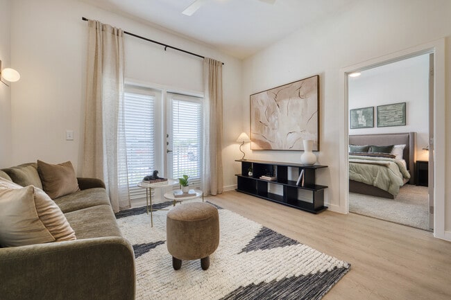 Bright living room with a ceiling fan and patio or balcony access at Sageland Flats at Brooks - Sageland Flats at Brooks