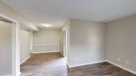 Located at 409 Tradewinds Dr in Fayetteville, NC, this single-floor, one-bedroom, one-bathroom unit offers a well-organized and functional layout with consistent neutral tones throughout. The living area features wood-look plank flooring, warm beige walls, clean white baseboards, and a window that brings in natural light, creating a bright, open feel. A hallway connects the main living space to the rest of the unit seamlessly.

The kitchen is well-appointed with crisp white shaker-style cabinetry, a subway tile backsplash, light granite-style countertops, and a full suite of black appliances including a refrigerator, range, microwave, and dishwasher. Wood-look flooring continues here, adding cohesion to the space.

The bedroom is a comfortable size, featuring two windows that fill the room with natural light and darker wood-look plank flooring. It includes access to a dedicated walk-in closet with dual hanging rods and carpeted flooring, offering generous storage. A separate carpeted room with a window and ceiling fixture provides additional flexible living space.

The bathroom features a full-size soaking tub with a shower and clean white surround. Throughout the unit, the design is clean, neutral, and move-in ready.