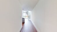 This contemporary dwelling spans 1,470 square feet across two floors, offering a harmonious blend of style and functionality. The ground floor, measuring 740 square feet, showcases an open-concept layout that seamlessly integrates the kitchen and living areas. Large floor-to-ceiling windows dominate the space, flooding the interior with natural light and providing panoramic views of the surroundings. The focal point of the room is an elegant spiral staircase, its sleek metal design adding a touch of modern sophistication.

The upper level, comprising 730 square feet, is accessible via the striking spiral staircase. This floor likely houses the private spaces, including bedrooms and additional bathrooms. The property boasts a total of two bathrooms and two closets, ensuring ample storage and convenience for residents.

Throughout the home, warm wood flooring creates a welcoming atmosphere, contrasting beautifully with the crisp white walls. The minimalist design aesthetic is evident in the clean lines and uncluttered spaces, allowing the architectural features to take center stage. This residence is ideal for those who appreciate contemporary design, abundant natural light, and a thoughtful layout that maximizes both form and function.