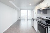 Located in Seattle's Capitol Hill neighborhood at 1500 12th Avenue, Unit 514 is a one-bedroom, one-bathroom residence designed with a clean, contemporary aesthetic throughout. The single-floor layout is efficiently arranged, with an open-concept living and kitchen area that maximizes usable space and promotes a sense of openness.

The kitchen runs along one wall and is outfitted with stainless steel appliances, including an electric range with overhead ventilation, a refrigerator, and a sink. White cabinetry extends to the ceiling, providing generous storage, while dark countertops offer a subtle contrast. The kitchen transitions seamlessly into the living area, which features hard-surface flooring and neutral white walls that lend a bright, versatile backdrop.

A large window in the living area allows natural light to fill the space and frames views of the surrounding Seattle cityscape, creating a pleasant connection to the urban environment outside. Recessed lighting complements the natural light throughout.

The bedroom is a well-proportioned private space with its own window and hard-surface flooring, offering a quiet retreat within the unit. The bathroom features a full tub and shower combination, a white vanity with under-sink storage, a large mirror, and tile flooring, all finished in a clean, minimal style consistent with the rest of the unit.
