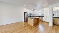 Located along Weber River Pkwy in Ogden, Utah, this well-appointed 2-bedroom, 3-bathroom residence is thoughtfully laid out across three floors. The main living level features an open-concept kitchen and living area with light hardwood flooring throughout. The kitchen is outfitted with crisp white cabinetry, dark granite countertops, a wood-accented center island, stainless steel appliances including a refrigerator, range, microwave, and dishwasher, and globe pendant lighting. The adjacent living area is bright and airy, with a glass door leading to an outdoor space and large windows inviting generous natural light. Two full bathrooms on the upper floors share a consistent design aesthetic — warm wood vanities, granite countertops, and full tub-shower combos with hardwood-style flooring. The spacious primary bedroom features tall ceilings and a trio of windows offering lush tree-lined views, complemented by plush carpeting and a generously sized walk-in closet with built-in rod storage. The secondary bedroom also offers carpeted flooring and a large window with neighborhood views. A dedicated laundry room with side-by-side washer and dryer adds everyday convenience. Clean white walls and modern finishes are consistent throughout the home.